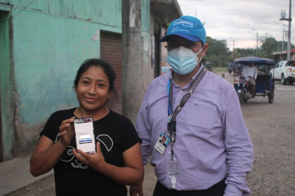 Emprendedora de Financiera Confianza usando internet gracias a la antena satelital, junto a su asesor