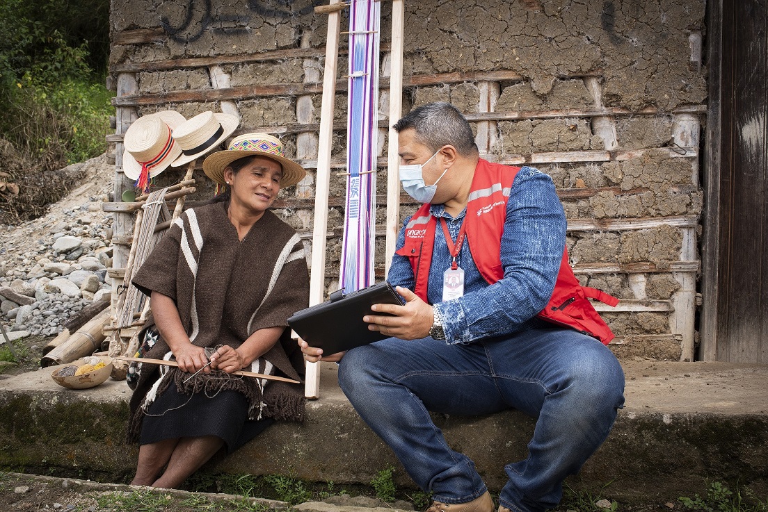 Florinda Chavez, artesana colombiana FMBBVA, con su asesor usando la tableta,